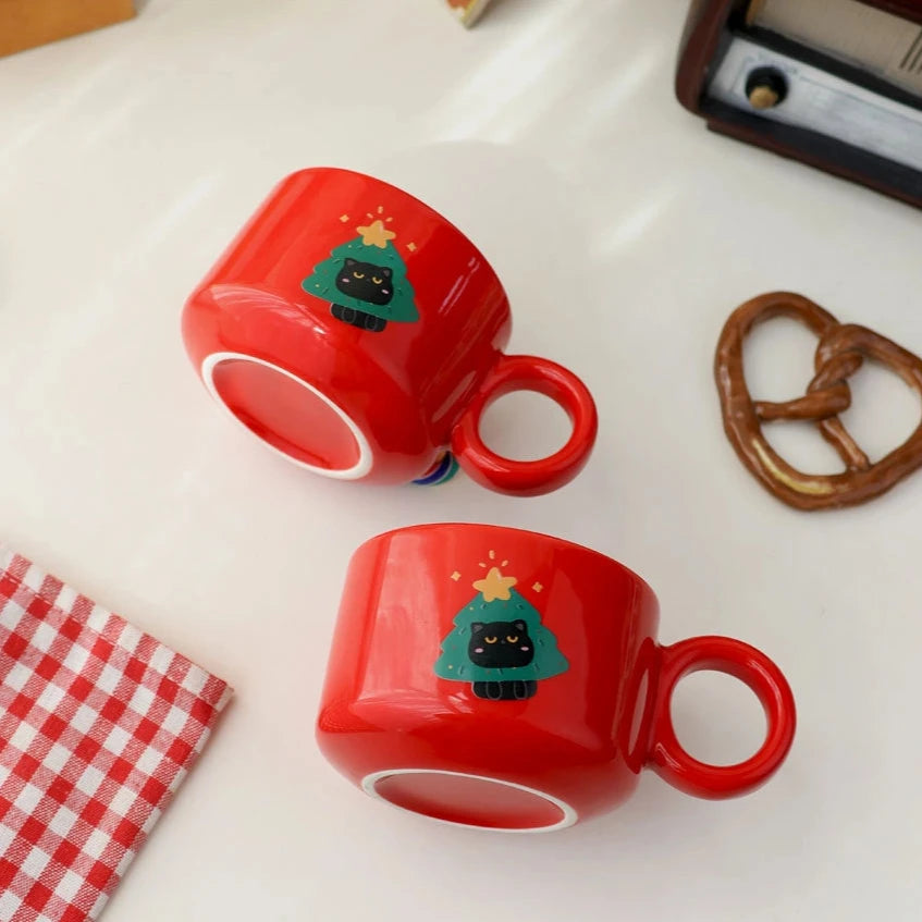 Red ceramic holiday mug with a cute black cat and Christmas-themed decorations.