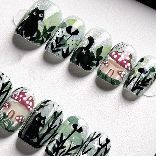 Handmade press-on nails with a black cat in a magical forest, surrounded by mushrooms and greenery, from the Whiskers in Wonderland collection.
