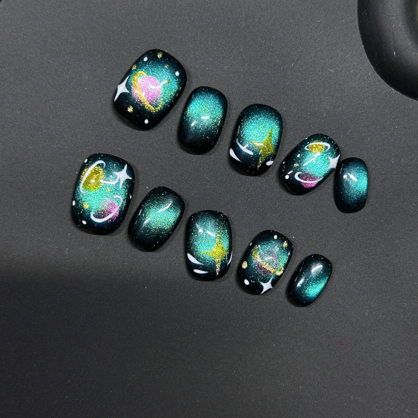 Cosmic Kitty Sparkle cat-eye press-on nails with a glittery space theme featuring hearts, stars, and galaxy swirls.