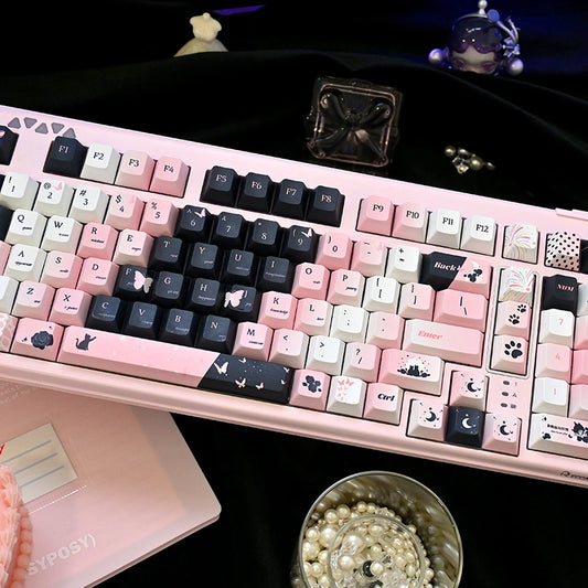 Cute black cat and pink keycaps arranged on a stylish keyboard for gamer girls