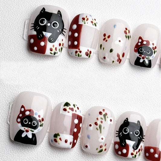 Cute cat nail art press-on nails with red, white polka dots, and floral patterns