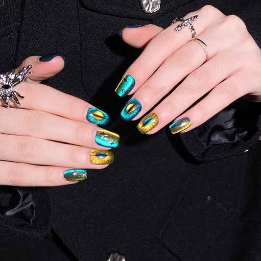 Model wearing Feline Glow Show Press-On Nails with vibrant cat-eye design in blue and gold.