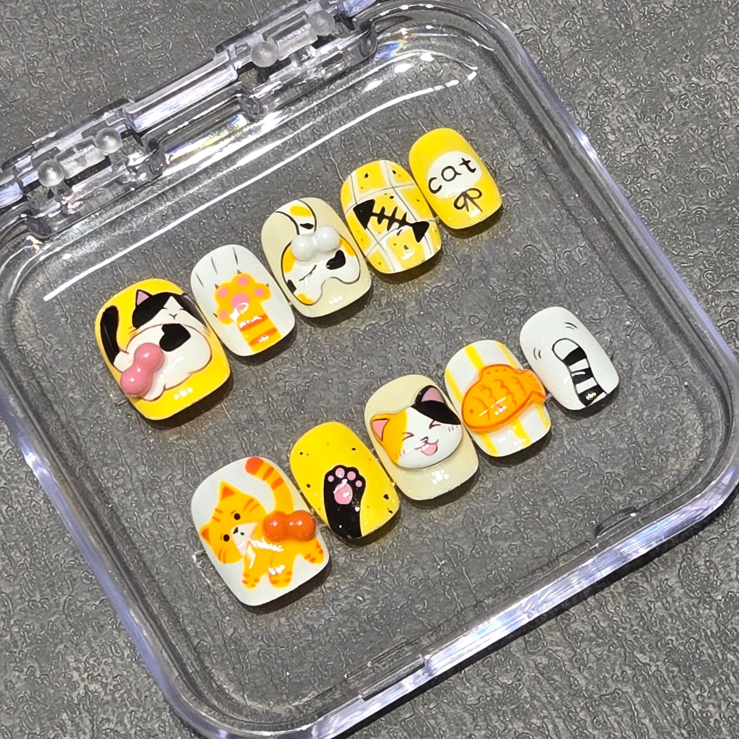 Handmade cat-themed nail art with playful ginger and calico cat designs for cat ladies