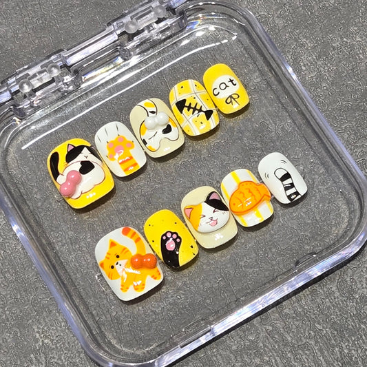 Handmade cat-themed nail art with playful ginger and calico cat designs for cat ladies