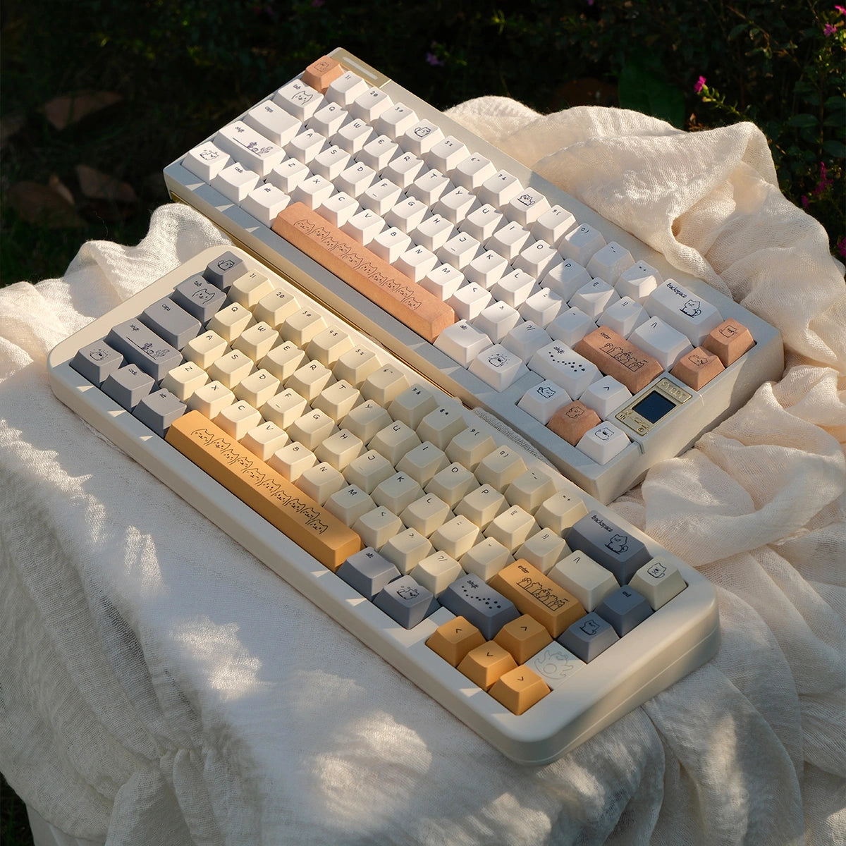 Mechanical keyboard keycap set with a sleek white and sand-gold color palette and cat motifs.