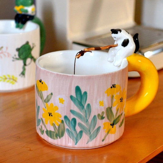 Cat Go Fishing Handmade Coffee Mug, Pink mug with flower print, Tuxedo Cat sitting on the mug with fishing rod in it's hand
