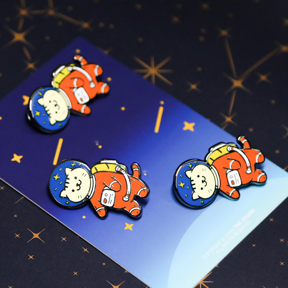 3 Cat Astronaut Pins on the paper back. the paper back printed the blue sky with stars. pawsome gift for cat lovers and ginger cat owners.