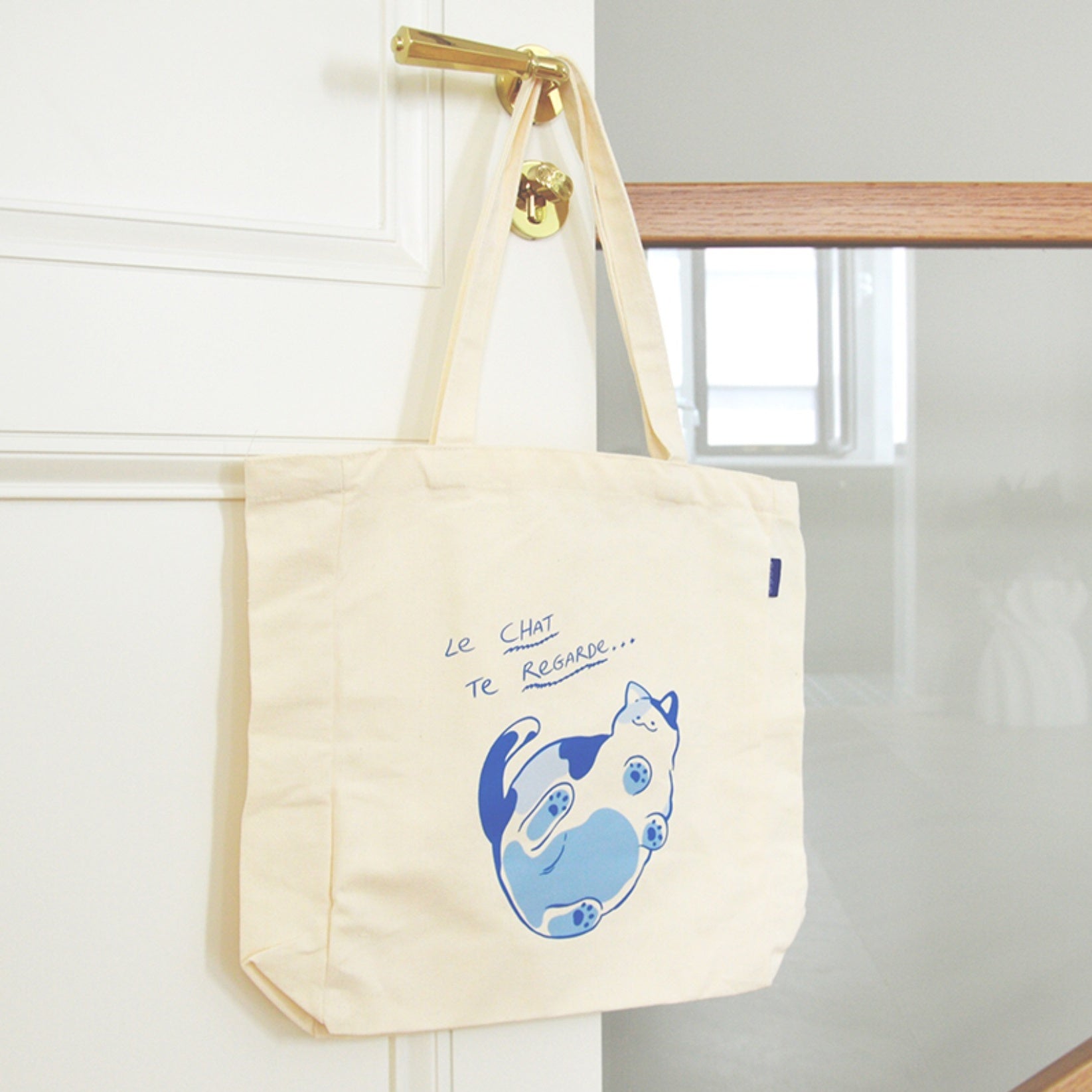 White Cat On Glass Canvas Shopping Tote hanging on the door. it is an ideal bag for beach, teachers, nurse, work, travel, swimming, sport, yoga, dance, travel, carry-on, luggage, camping, hiking, team work picnic, party, gym, library, spa, trade show, wedding, conference, etc.