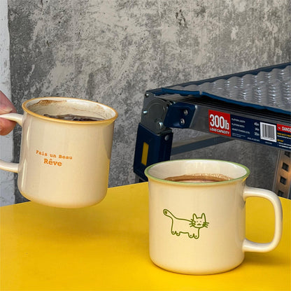 Friends holding the Fais un Beau Rêve Coffee Mugs Cheers. One hold the Matcha Colors and Another holds the Orange. Latte and Americano in Mugs.