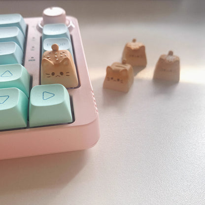 Handmade Bread Cat Mechanical Keyboard Keycap, Sesame Bread on a Mechanical Keyboard and White Bread, Vanilla Bread, and Chocolate Bread in the Background