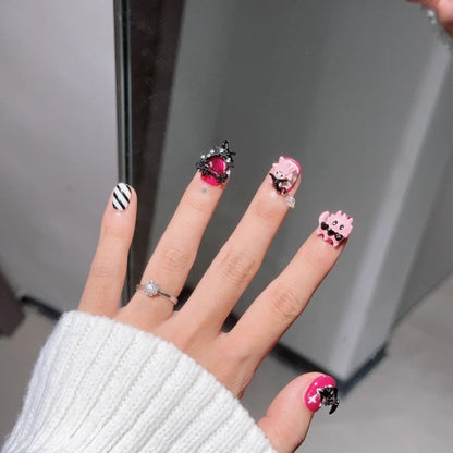 Halloween-inspired press on nails featuring gothic cats and pink accents