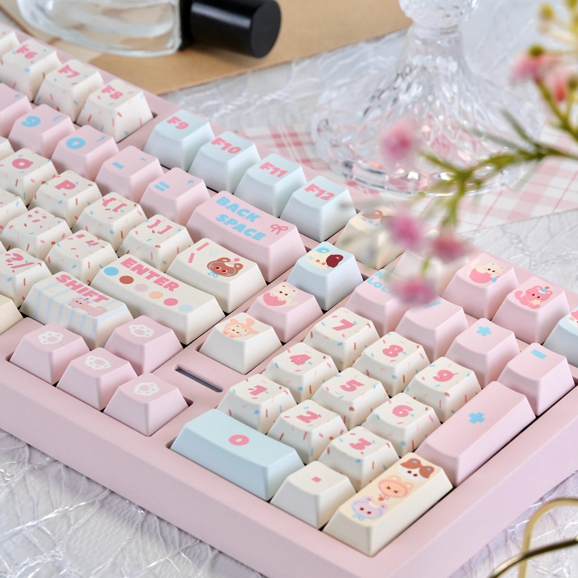 Close-up of pink and cream keycaps with cute cat icons and cherry profile

