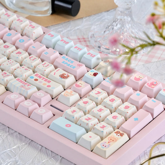 Close-up of pink and cream keycaps with cute cat icons and cherry profile

