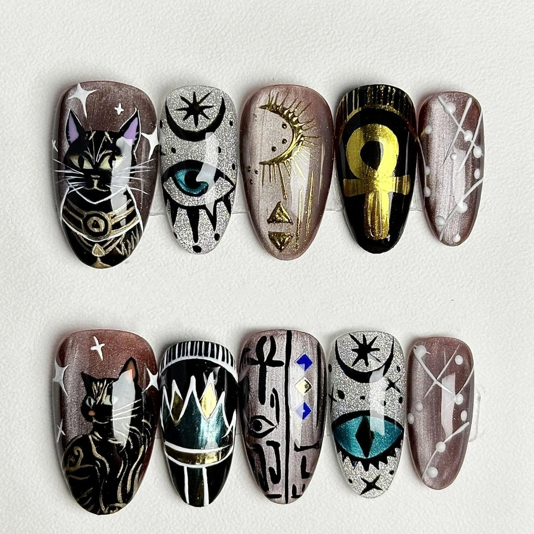 Handcrafted nail art featuring whimsical cat designs with mystical elements.