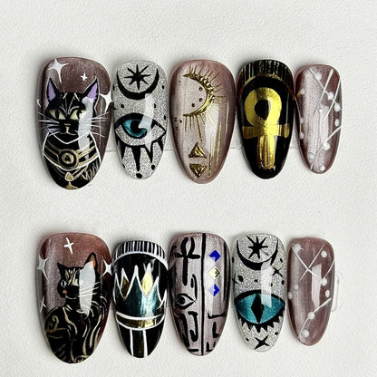 Handcrafted nail art featuring whimsical cat designs with mystical elements.