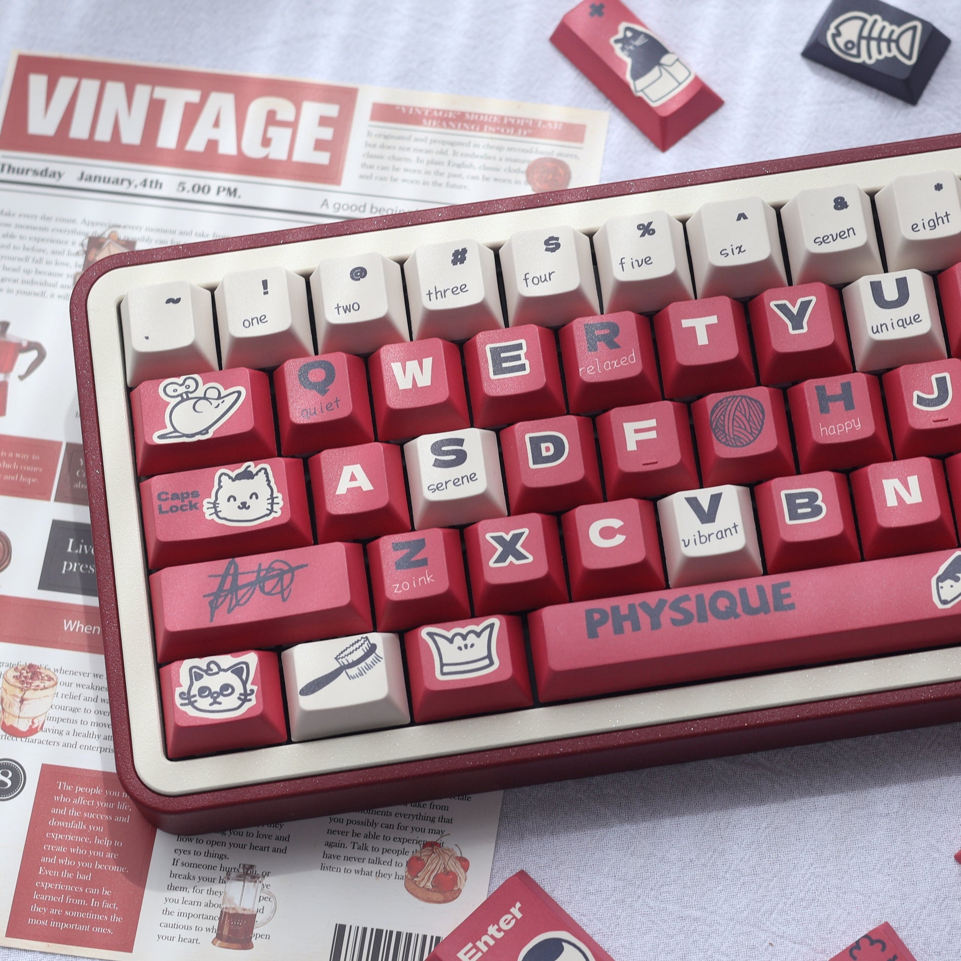 Close-up view of the Paws and Claws Showdown Keycap Set featuring red, beige, and black keycaps with cat and dog battle illustrations.