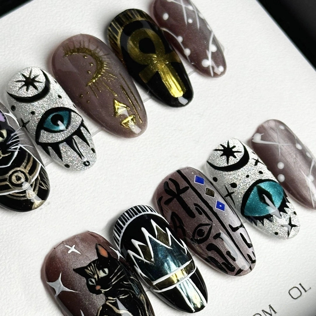 Unique handcrafted nails showcasing playful cat motifs and enchanting symbols.